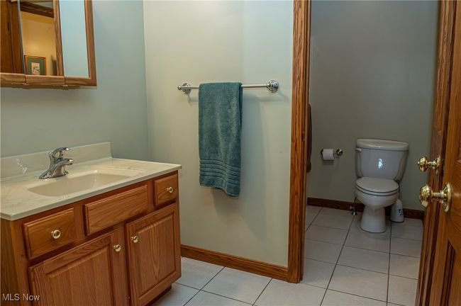 Bathroom with baseboards, toilet, tile patterned flooring, and vanity | Image 17