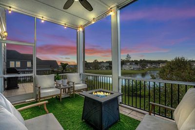 Sunroom featuring a water view, ceiling fan, and rail lighting | Image 3