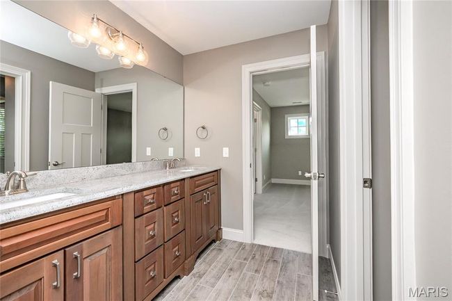 Bathroom featuring double vanity, wood finished floors, and baseboards | Image 36