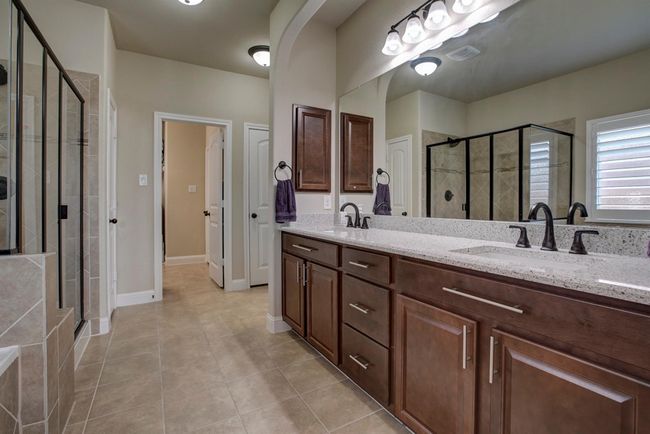 Bathroom with a shower stall, double vanity, and tile patterned flooring | Image 18