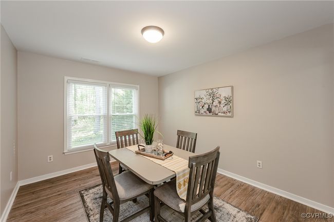 Dining room with baseboards, wood finished floors, and visible vents | Image 16