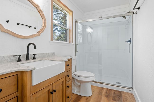 Bathroom with a shower stall, wood finished floors, vanity, and toilet | Image 29