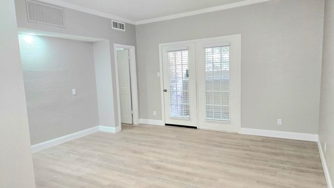 Empty room with crown molding, light wood-type flooring, and baseboards | Image 10