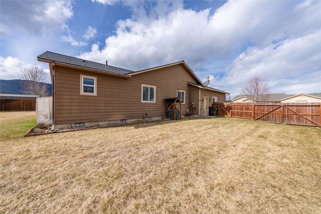 Back of property featuring crawl space, a lawn, and fence | Image 23