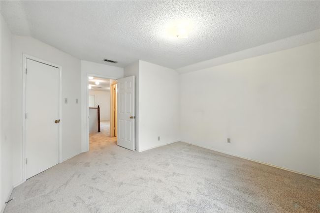 Unfurnished bedroom featuring light carpet and a textured ceiling | Image 31