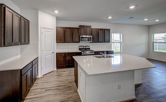 Kitchen featuring appliances with stainless steel finishes, a sink, plenty of natural light, light wood-style flooring, and recessed lighting | Image 11