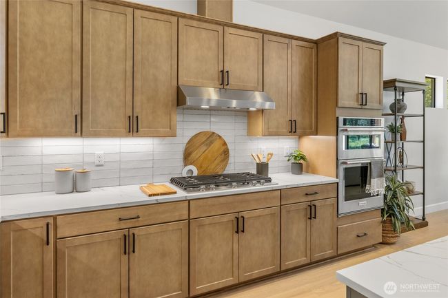 Gourmet kitchen with gas cooktop and stainless steel extraction hood. | Image 9