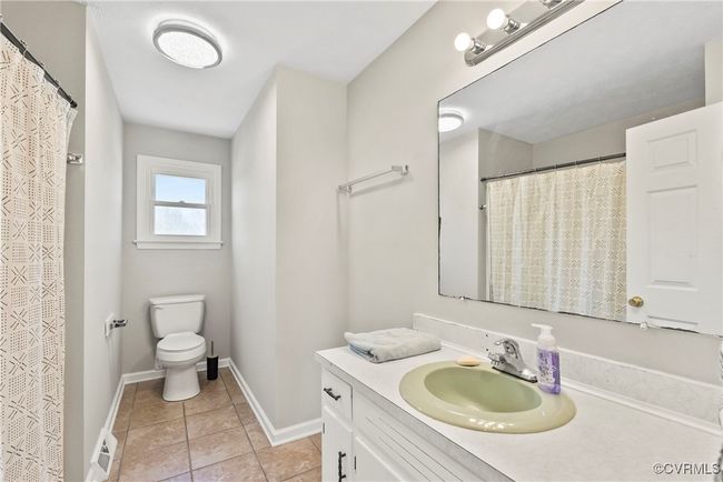 Full bath featuring toilet, vanity, tile patterned flooring, baseboards, and visible vents | Image 11