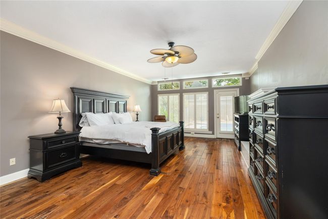 The spacious primary bedroom features wood floors, soft natural light, and serene wall tones. Large windows and private backyard access make this room feel both peaceful and connected to the rest of the home.The spacious primary bedroom features wood floors, soft natural light, and serene wall tones. Large windows and private backyard access make this room feel both peaceful and connected to the rest of the home. | Image 22