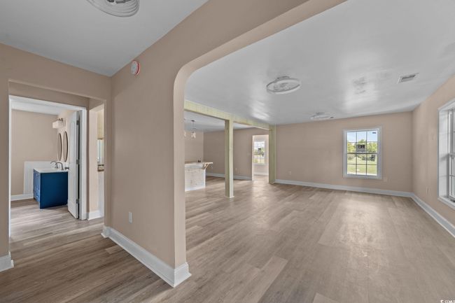 Unfurnished room featuring light wood-style flooring and arched walkways | Image 18