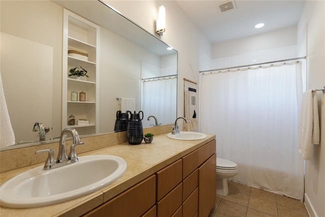 Full bath featuring toilet, double vanity, and tile patterned flooring | Image 26