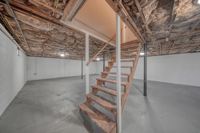 Unfinished below grade area featuring concrete block wall and stairs | Image 25
