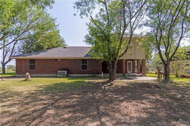 Back of property featuring brick siding, cooling unit, and a patio area | Image 19