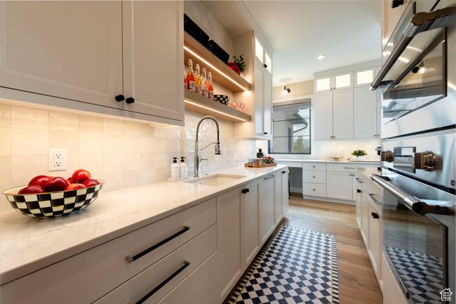 Kitchen with white cabinetry, light stone countertops, stainless steel double oven, tasteful backsplash, and recessed lighting | Image 23