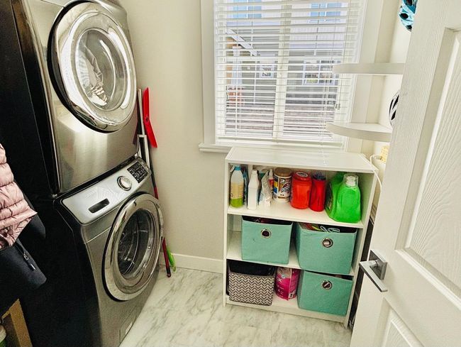 Laundry room with stacked washer / dryer and marble look tile flooring | Image 12