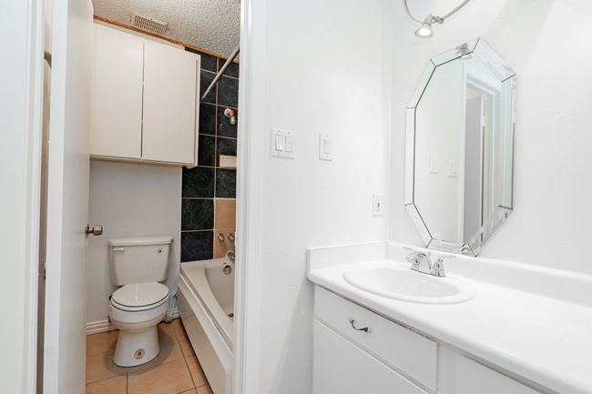 Full bath with a textured ceiling, toilet, visible vents, tile patterned flooring, and vanity | Image 21