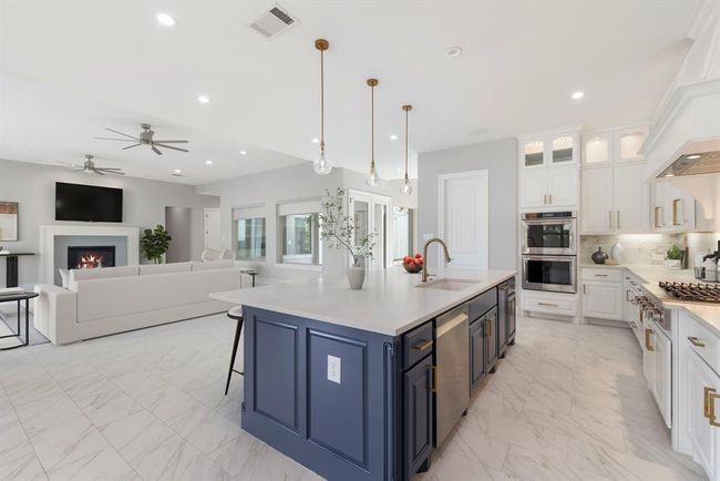 With an open-concept flow that seamlessly connects the designer kitchen to the cozy living space, this heart-of-the-home layout offers effortless elegance, warm natural light. *This photo has been virtually staged.* | Image 11