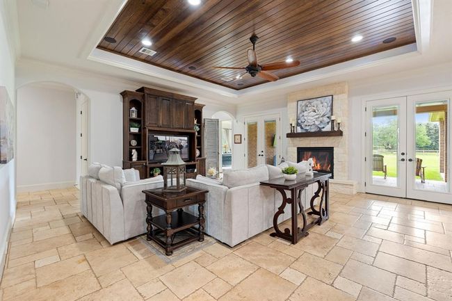 This spacious Family Room acts as the anchor of the home, thanks in large part to its direct access to just about every room of the home. The crown molding with wood paneled tray ceiling draws the eyes upward and adds an understated elegance to the space. | Image 9
