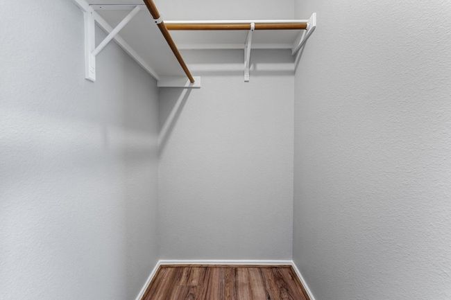 Spacious Primary Bedroom closet with wood finished floors | Image 14