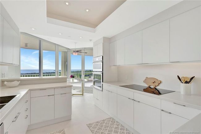 Crisp white cabinetry and limestone floors | Image 18