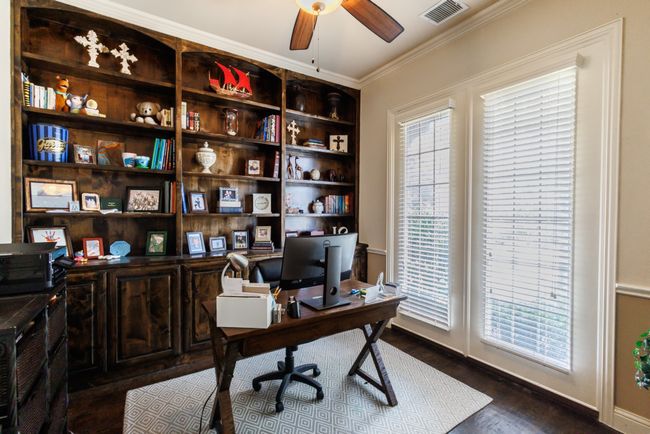 A secluded office space with crown molding, a ceiling fan, and crown molding. | Image 7