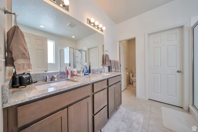 Bathroom featuring tile patterned flooring, toilet, a sink, and a stall shower | Image 14