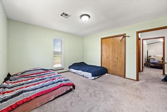 Bedroom with carpet flooring, baseboards, and a closet | Image 28