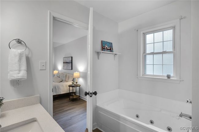 Ensuite bathroom with a jetted tub, wood finished floors, and vanity | Image 14