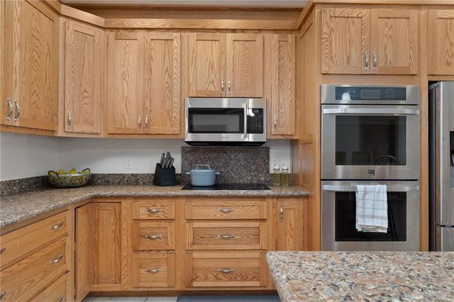 Kitchen featuring light stone countertops, appliances with stainless steel finishes, and light brown cabinetry | Image 4