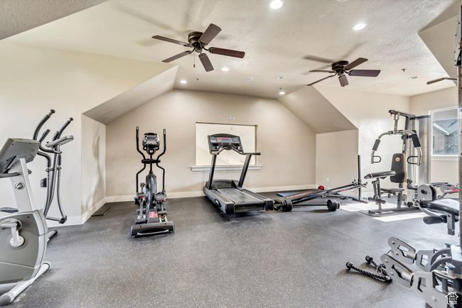 Exercise room featuring a ceiling fan, recessed lighting, lofted ceiling, and a textured ceiling | Image 11