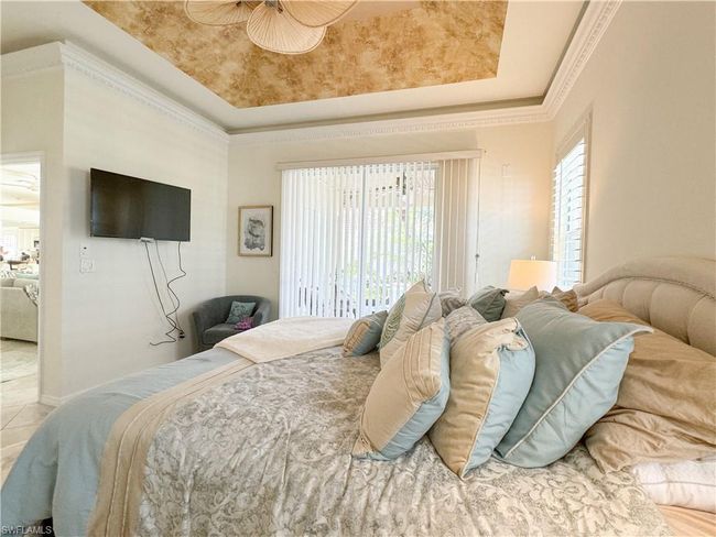 Tiled bedroom featuring ornamental molding and a raised ceiling | Image 45