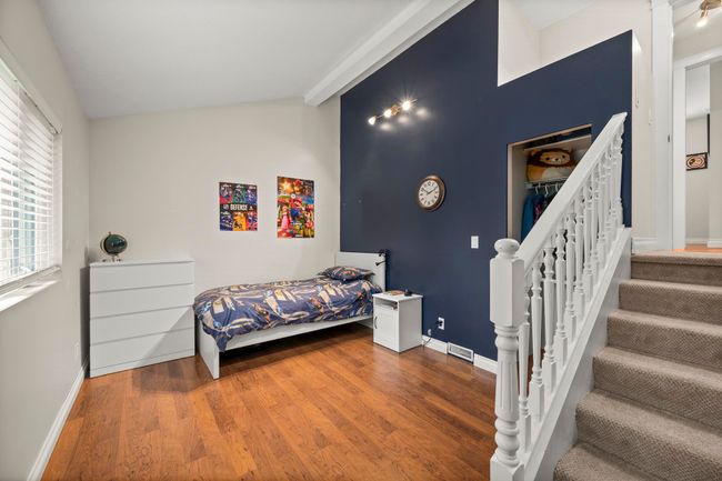 Bedroom with visible vents, baseboards, vaulted ceiling with beams, and wood finished floors | Image 23