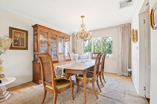 Dining area featuring a chandelier, light carpet, and ornamental molding | Image 6