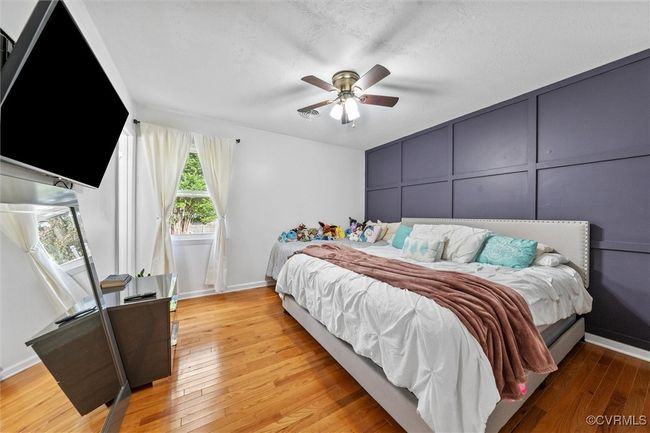 Bedroom with baseboards, ceiling fan, light wood-style flooring, and a decorative wall | Image 20