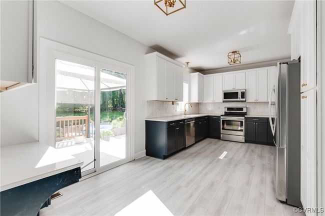 Kitchen view featuring upgraded sliding glass door, and drybar/desk space | Image 14
