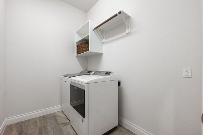 Washroom with laundry area, light wood-style flooring, baseboards, and separate washer and dryer | Image 24