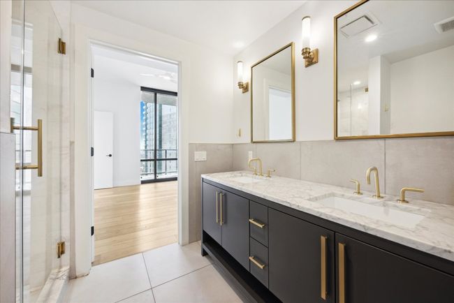 Full bathroom featuring double vanity, tile patterned flooring, and a stall shower | Image 13
