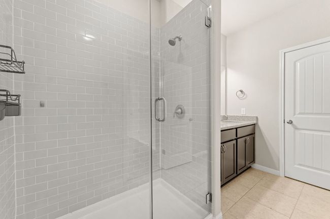 Bathroom featuring a shower stall, tile patterned flooring, vanity, and baseboards | Image 13