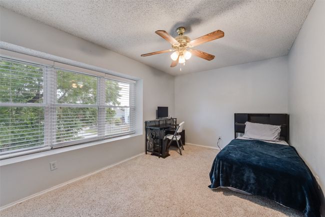 Carpeted bedroom featuring a desk, a textured ceiling, and ceiling fan | Image 23