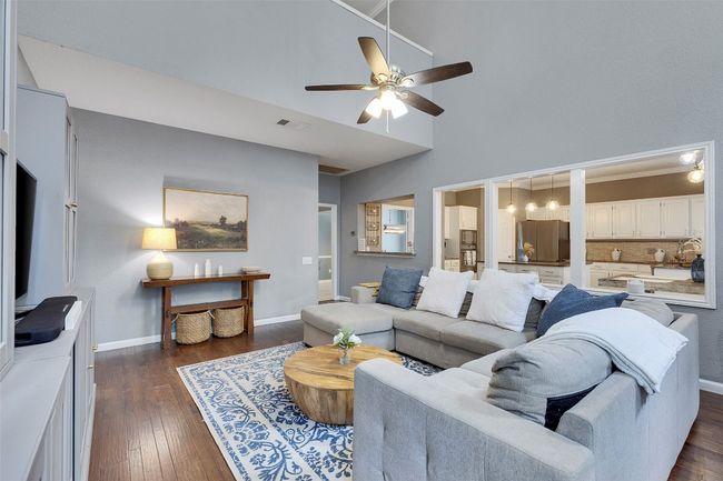 Living room with ceiling fan, dark wood-style floors, baseboards, and a high ceiling | Image 12
