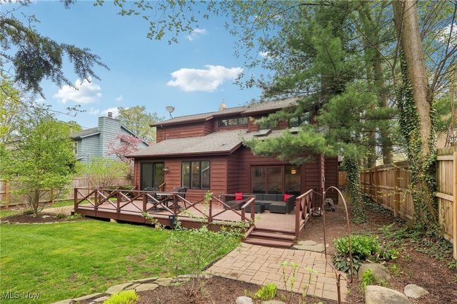 Back of house with a fenced backyard, a yard, an outdoor hangout area, a wooden deck, and roof with shingles | Image 37