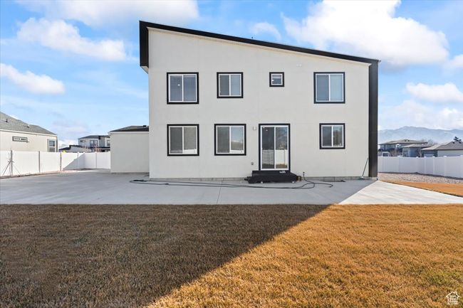 Back of house featuring a yard, a fenced backyard, a patio, and stucco siding | Image 28