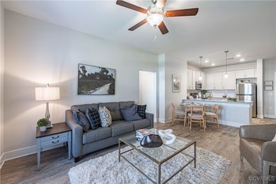 Living room with light wood-type flooring and ceiling fan | Image 1