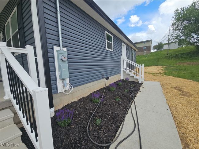 Landscaped and sidewalk with exterior entrance to laundry/utility room. | Image 6