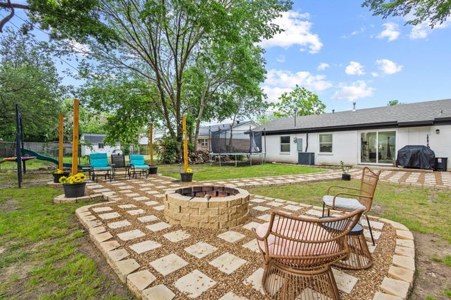 View of patio / terrace with a trampoline, a fire pit, cooling unit, and a grill | Image 10