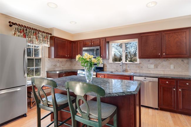 Kitchen featuring center island with seating, stainless steel appliances and hardwood floors | Image 16