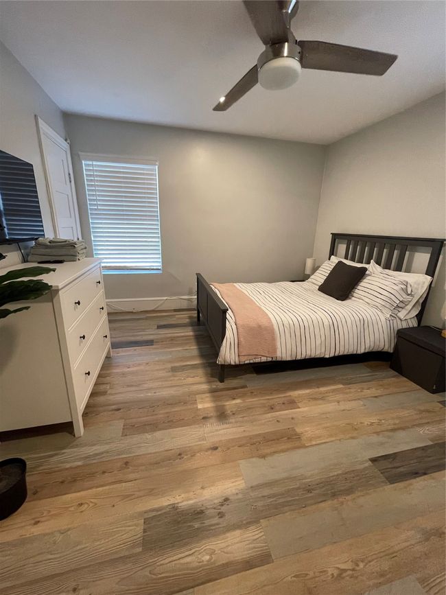 Bedroom with light wood-style floors and ceiling fan | Image 16