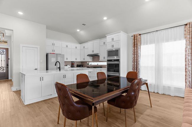 Dining space with lofted ceiling, light wood-style floors, and recessed lighting | Image 18