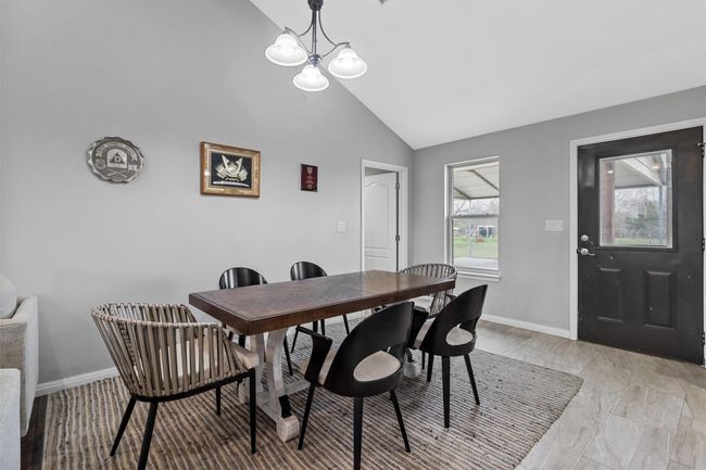Dining space featuring baseboards, high vaulted ceiling, and an inviting chandelier | Image 10