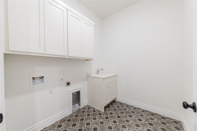 Laundry room featuring cabinet space, hookup for an electric dryer, washer hookup, and hookup for a gas dryer | Image 20